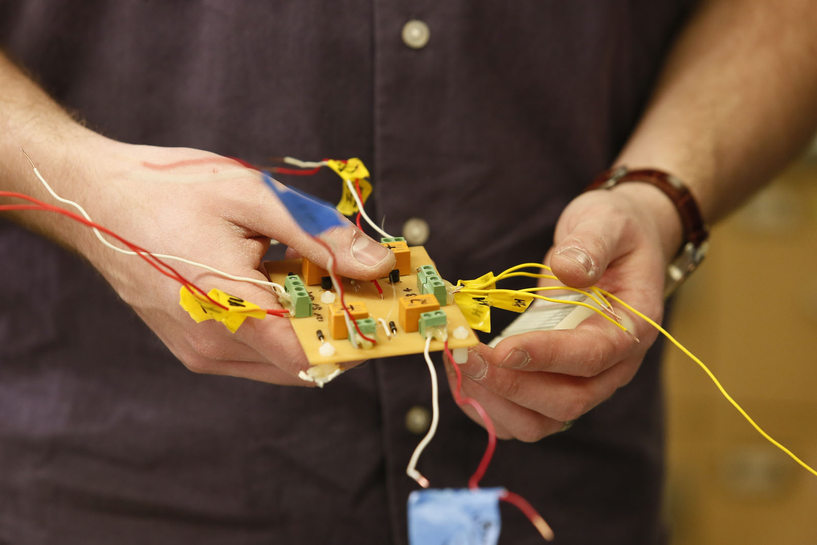 technician holding electrical unit with wires