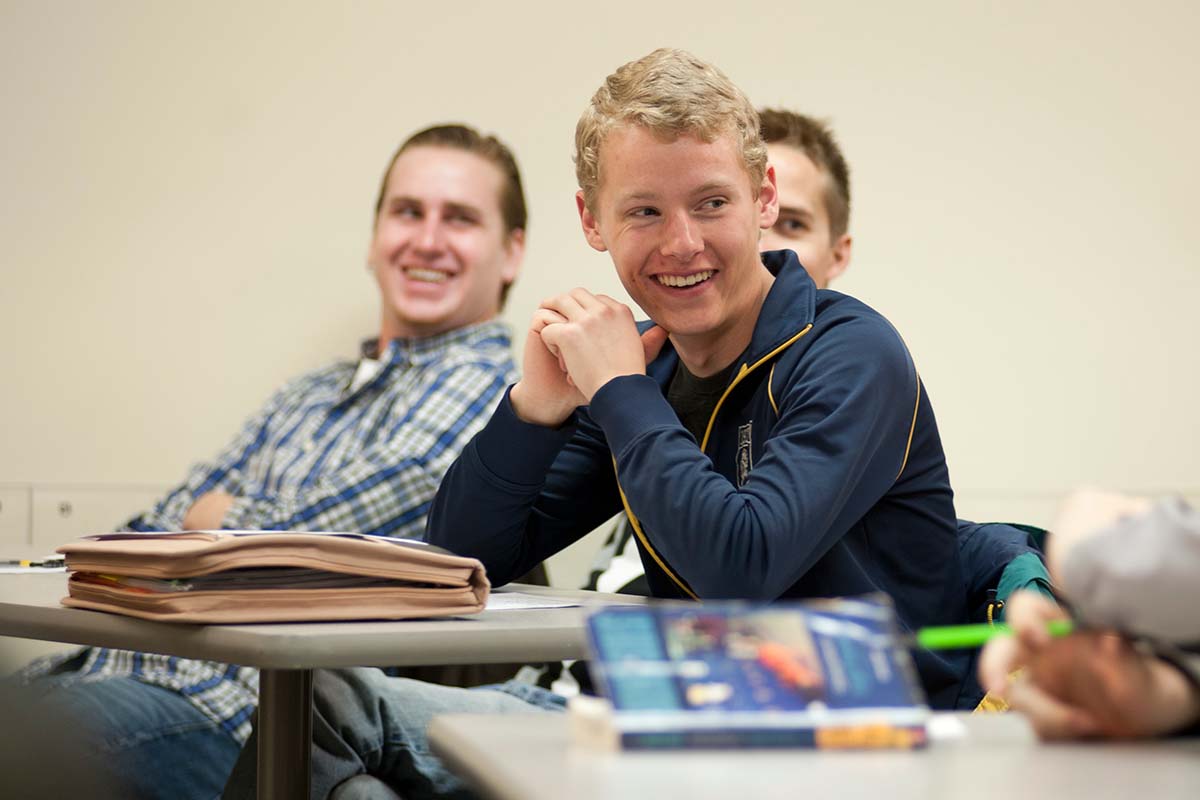 Three Students Smiling in Class