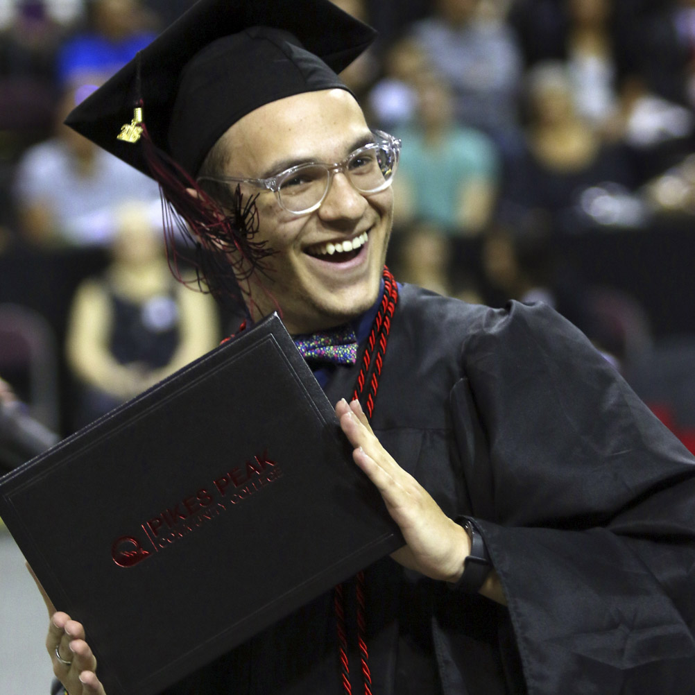 ppsc student holding up diploma cover at commencement ceremony 