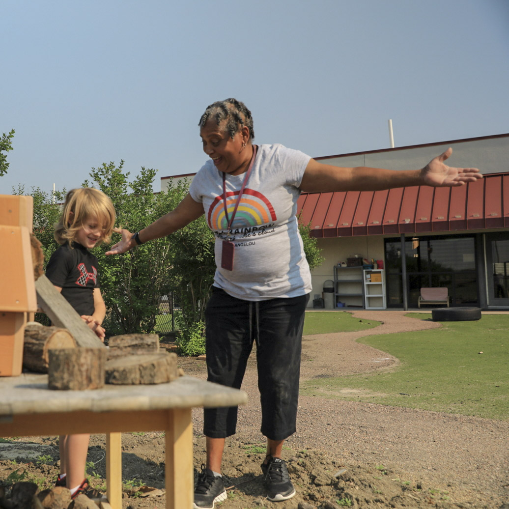 Educator working with young student outside 