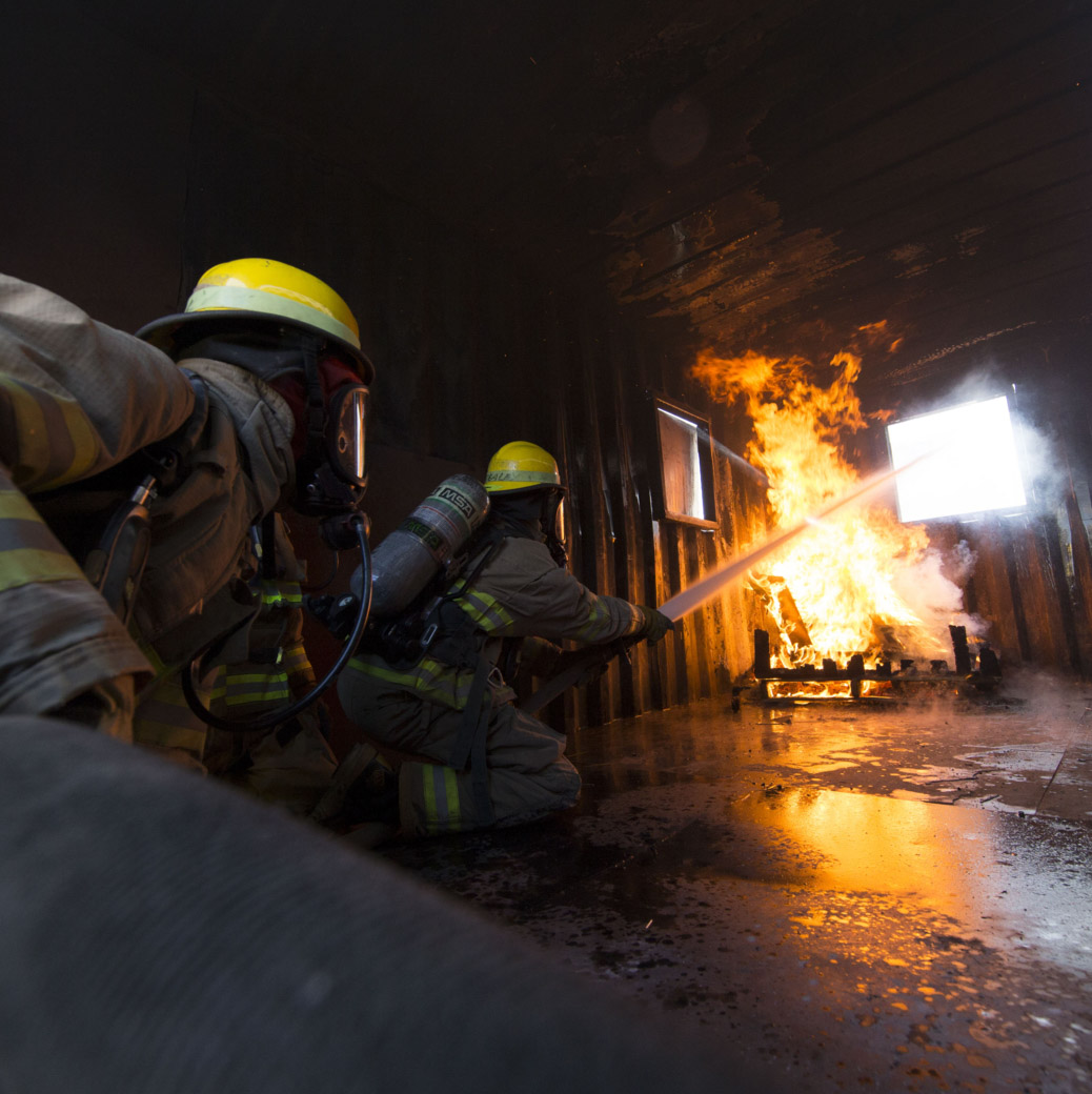 Two Academy students putting out a fire