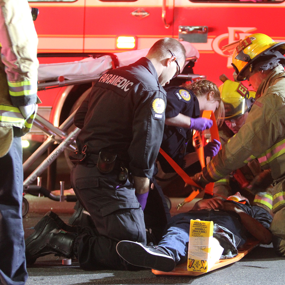 paramedic and firefighter helping patient in