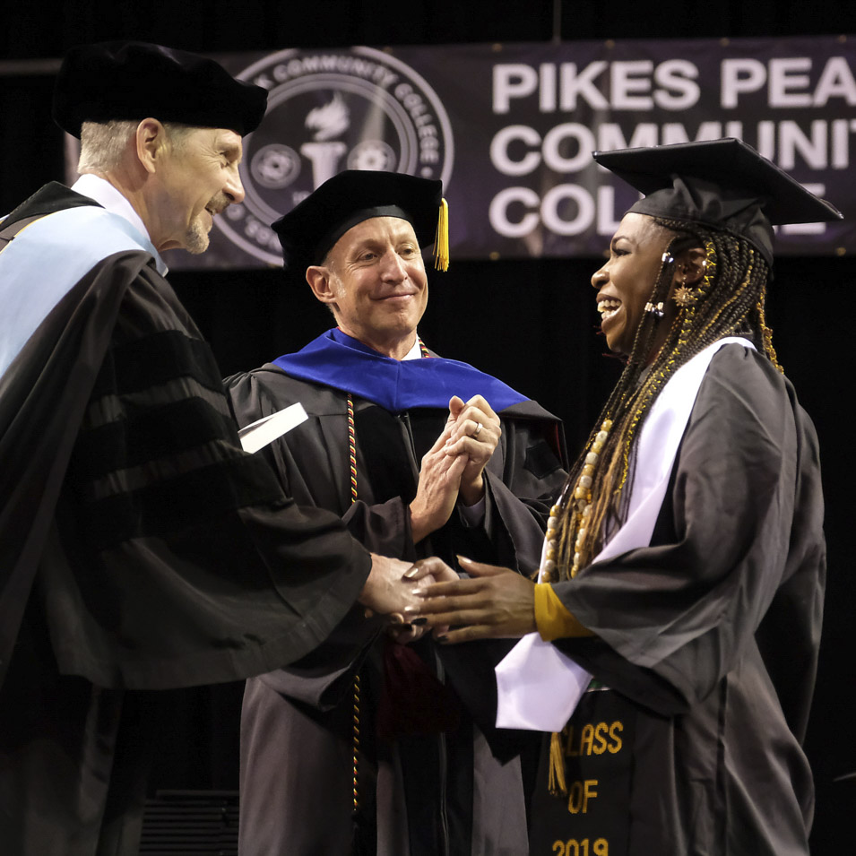 college administrations handing a student a diploma at graduation