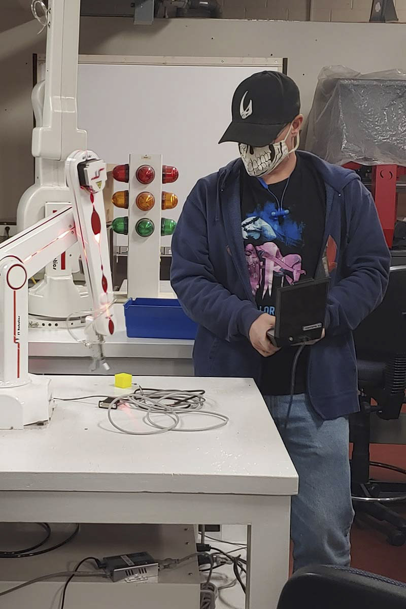 A student observing a robot arm