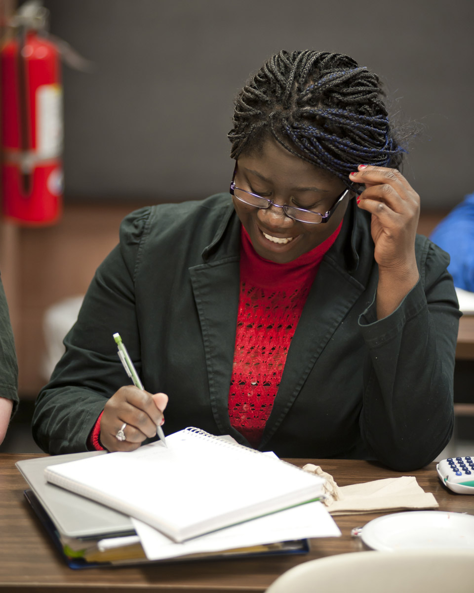 Girl with glasses writing in notebook