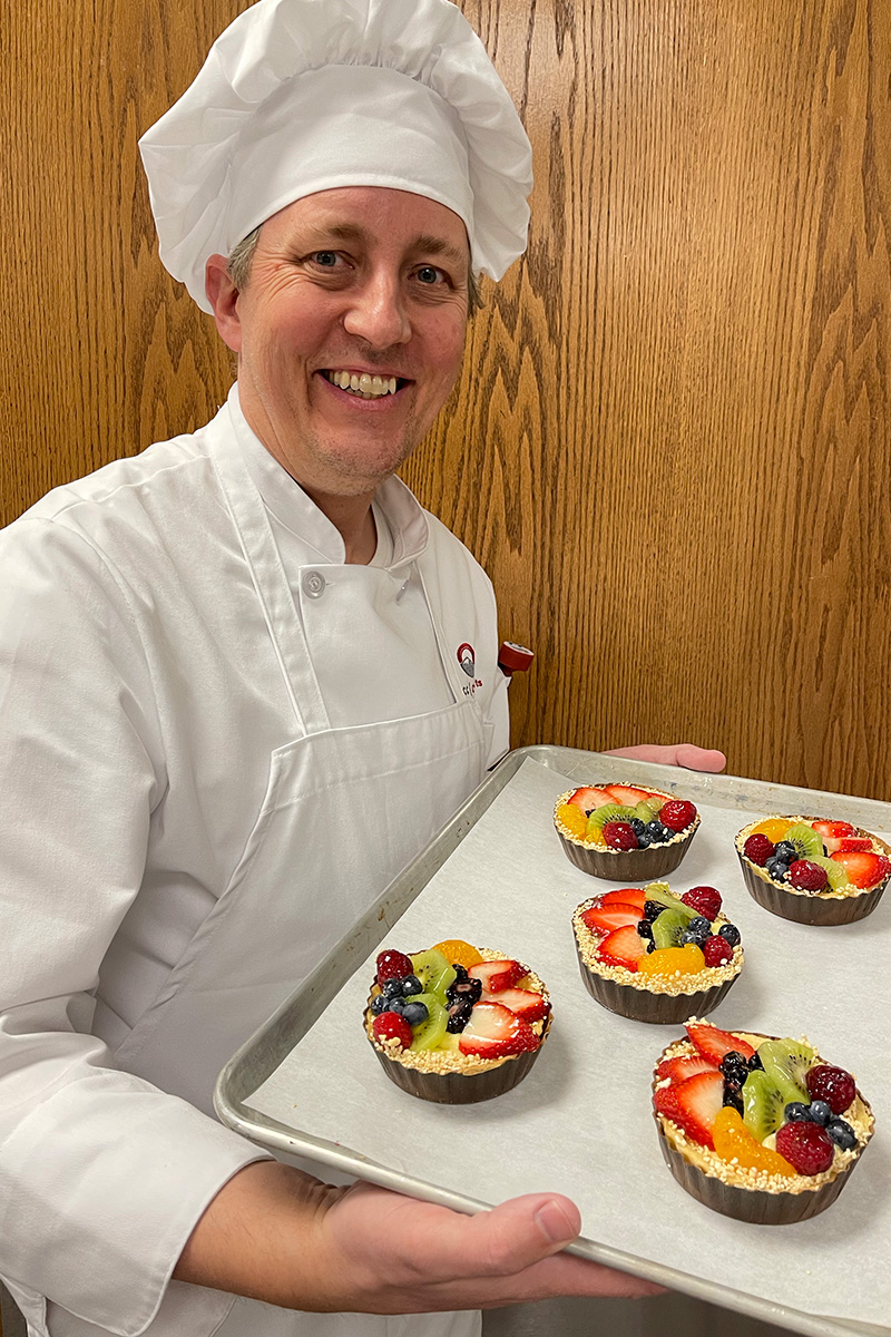 chef with fruit tarts
