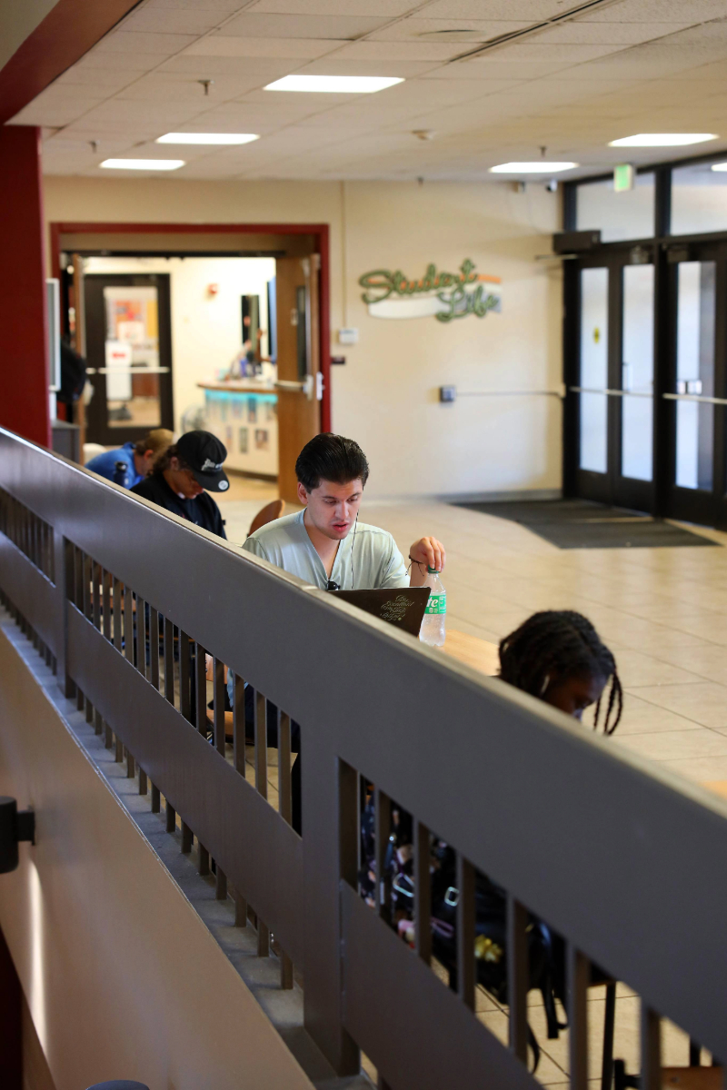 students on computer in hallway