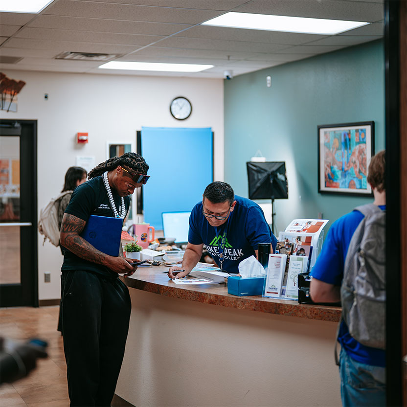 A student getting help at the desk of the admissions office