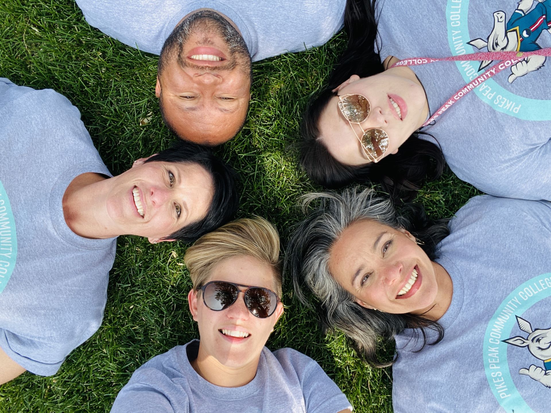 Advantage Coaches laying on the grass in a circle