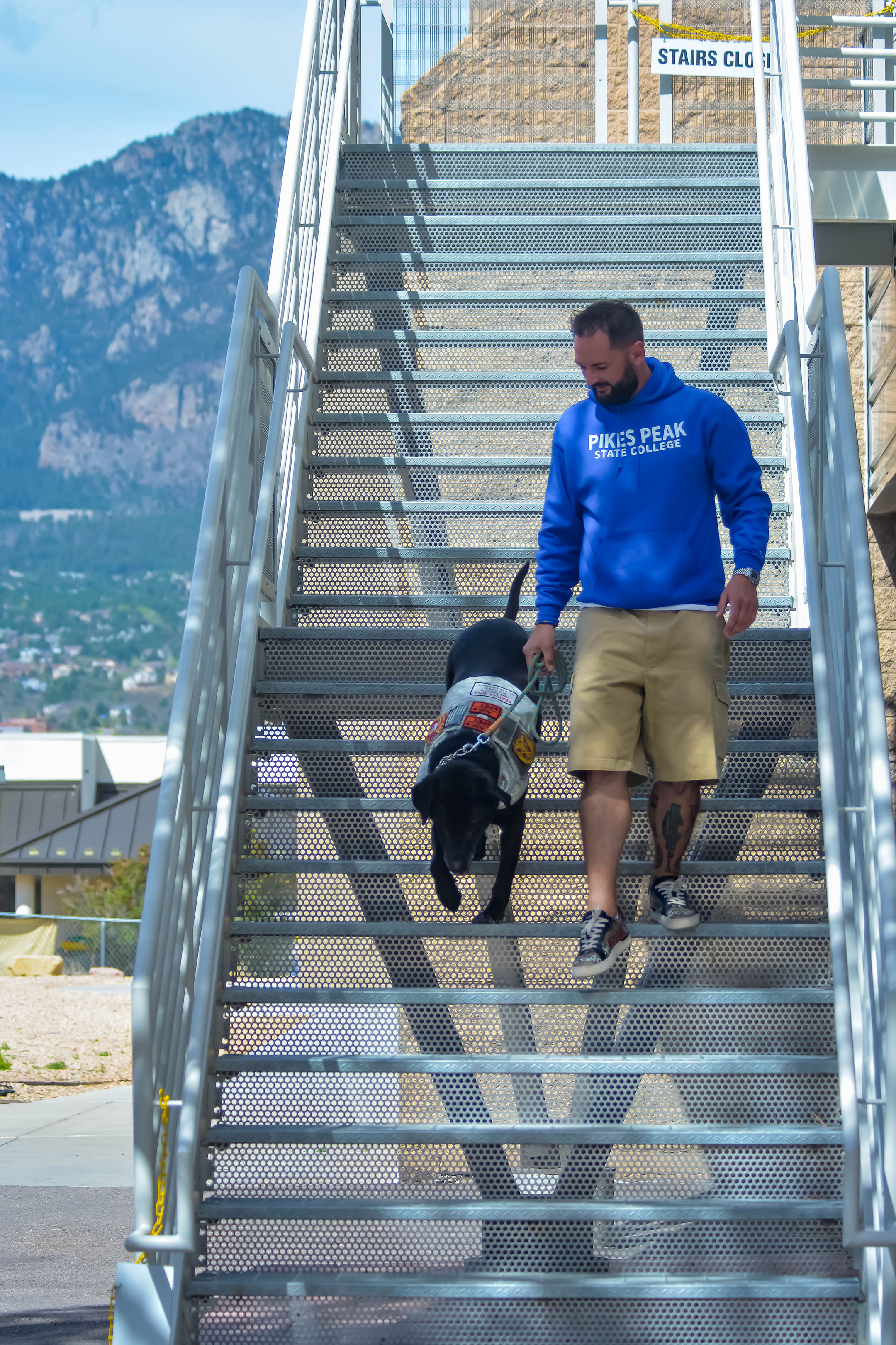 Veteran student walking down stairs with service dog
