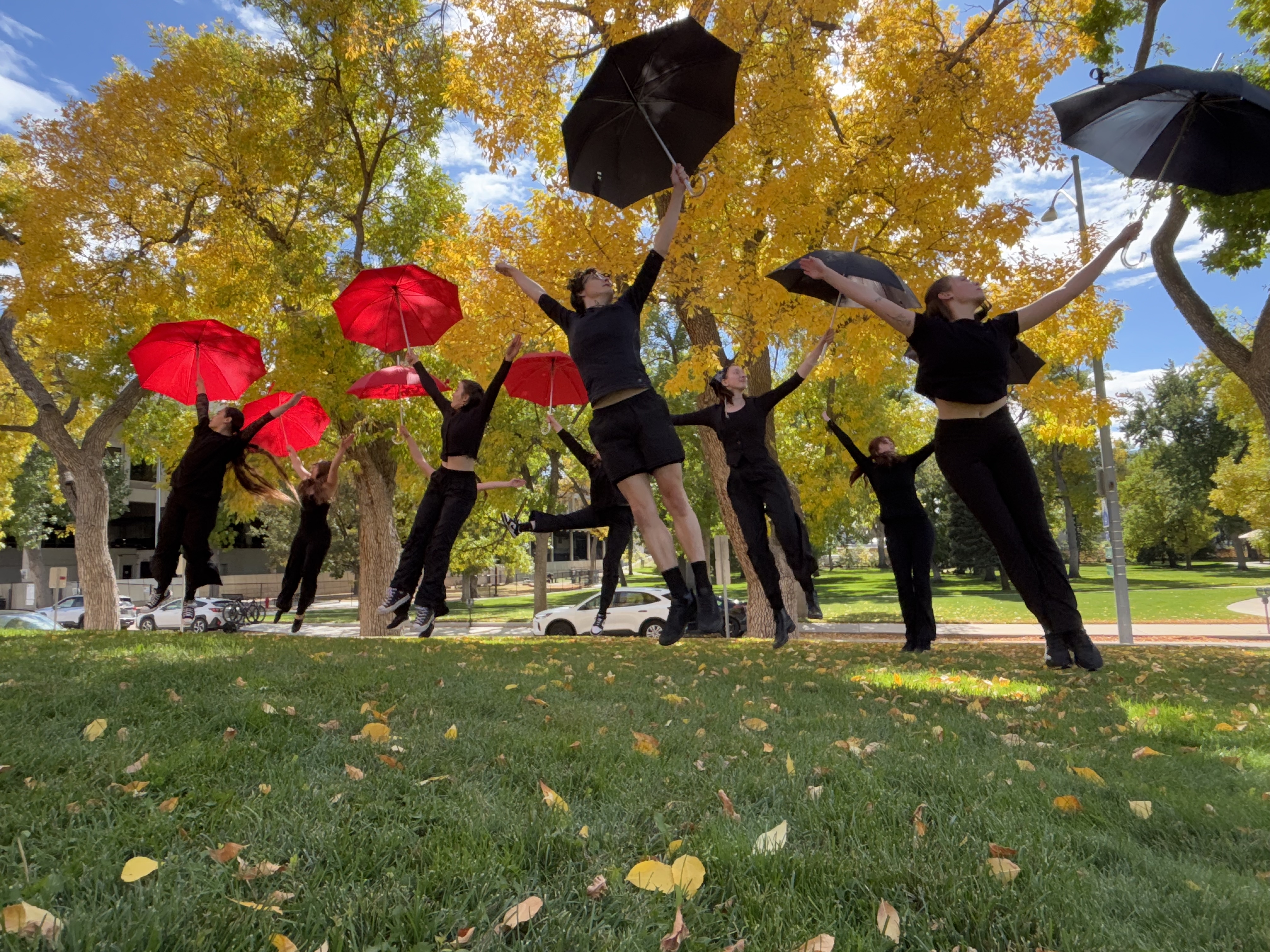 dance students jumping with umbrellas 